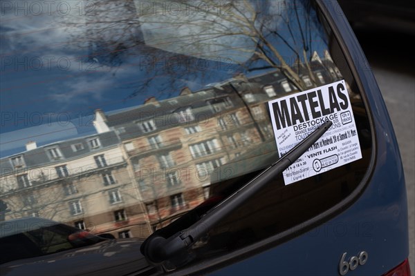 Paris, flyer sur le pare-brise arrière d’une voiture