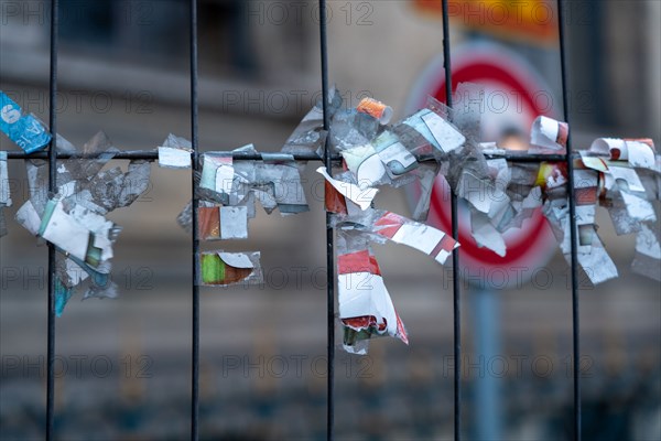 Paris, affiches arrachées d’un grillage