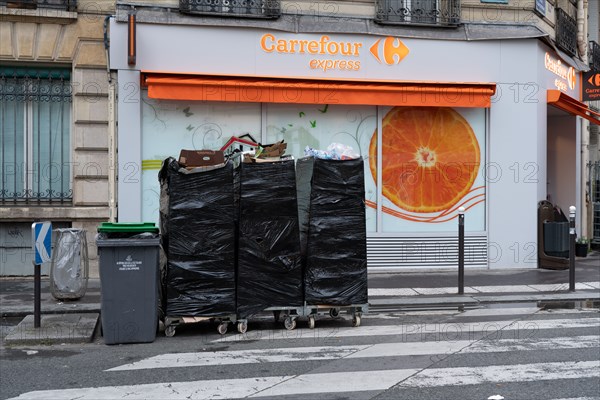 Paris, magasin d’alimentation et poubelles sorties