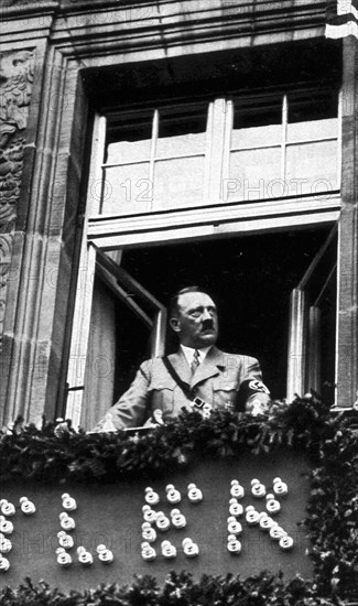 Adolf Hitler. In der Stadt der Parteitage. Am Fenster des Hotels ,,Deutscher Hof'' in Nürnberg. Journée du Parti. Le Führer à la fenêtre de l'hôtel Deutscher Hof à Nuremberg.