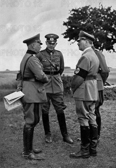 Adolf Hitler. Der Führer mit dem Reichskriegminister und dem Oberbefehlshaber des Heeres 1935 bei den Manövern auf dem Truppenübungsplatz Munsterlager. Le Führer avec le Ministre de la Guerre et le Commandant en Chef de l'Armée. 1935.