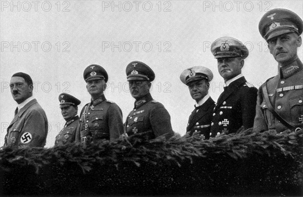 Adolf Hitler. Am Tage der Wehrmacht 1935: Der Führer mit seinem Oberbefehlshaber der Luftwaffe, Generaloberst Göring, der Wehrmacht, Generalfeldmarschall v. Blomberg, des Heeres, Generaloberst Freiherr v. Frischt, der Kriegsmarine, Generaladmiral Dr. h. c. Raeder. Le Führer avec le Haut Commandemant de l'Armée de l'Air.