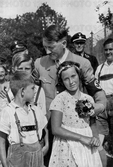 Adolf Hitler. Immer wieder sieht man den Führer auf Bildern von Kindern umgeben. Rechts Baldur von Schirach. Sur les photos, on voit toujours le Führer entouré d'enfants. Avec Baldur von Schirach, Ministre de la Jeunesse.