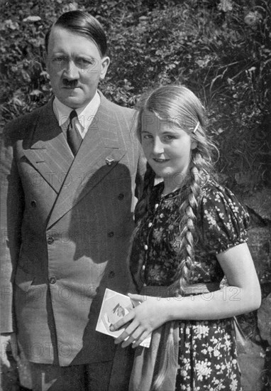 Adolf Hitler. Nachdem der Führer ihr ein Autogramm gab, hat sie auch noch das Glück, mit ihm photographiert zu werden. Après que le Führer lui ait donné un autographe, elle a encore le bonheur d'être photographiée avec lui.