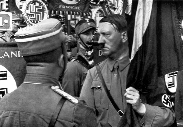Adolf Hitler. Der Führer weiht die Standarten auf dem Parteitage der Freiheit. Le Führer salue les étendrards à la Fête du Parti de la Liberté.