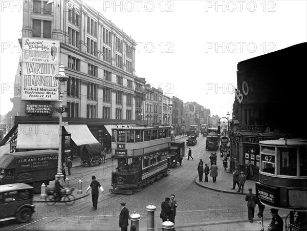 A policeman stands on point duty at the corner of Commercial Road, London