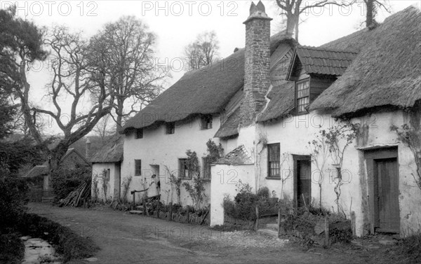 A pair of cottages with thatched roofs at Luccombe, Somerset, c1900.   Artist