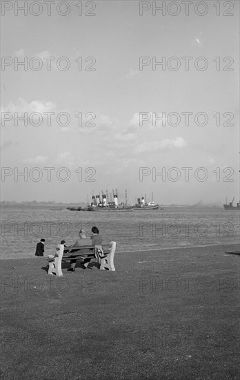 Two holidaymakers look out to sea on the promenade at Gravesend, Kent, c1945-c1965