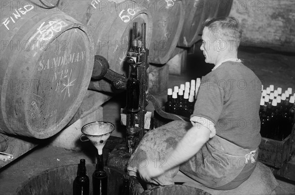 Port wine being bottled from the barrel at the Cutler Street warehouses, London, c1945-c1965