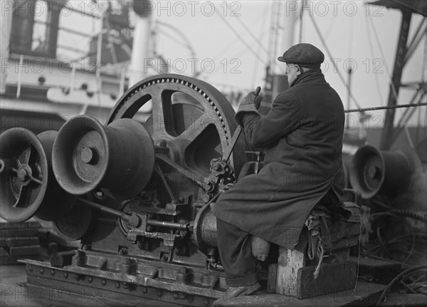 A docker operates a winching gear in London Docks, London, c1945-c1965
