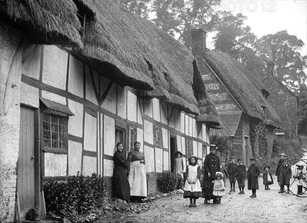 Women and children posing outside a thatched cottage, Ramsbury, Wiltshire, c1860-c1922