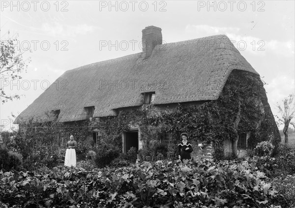 Thatched cottage with women standing outside, Shellingford, Oxfordshire, c1860-c1922