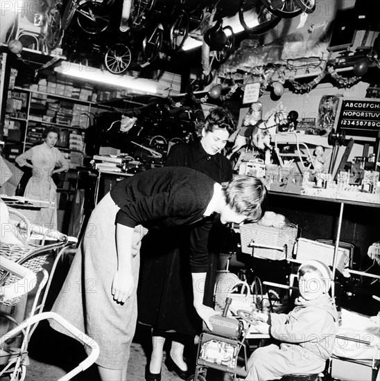 Child trying out a toy in a London toy store, c1950s. Artist: Henry Grant