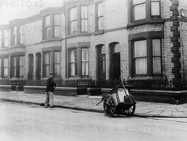 An 'Orderly Boy' and his cart sweeping a street, Liverpool, 1935. Artist: Unknown