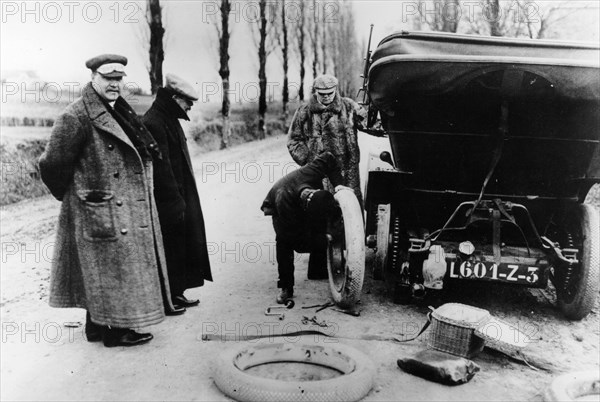 Lord Northcliffe's chauffeur changing a tyre, (c1908?). Artist: Unknown