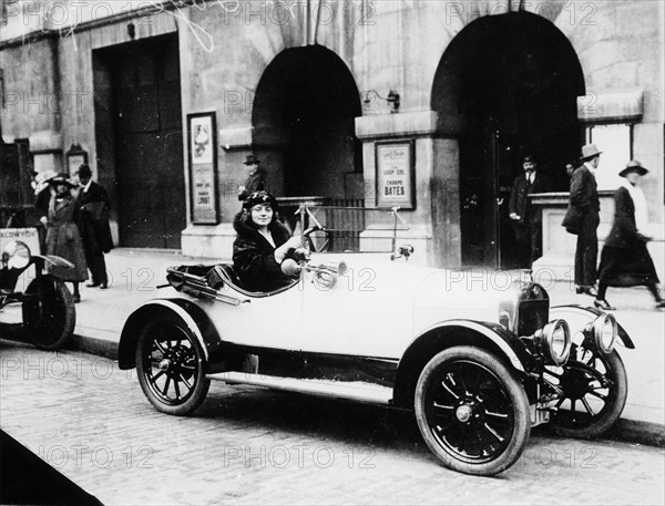 Miss Evelyn Laye sitting in a parked car, (1920s?). Artist: Unknown