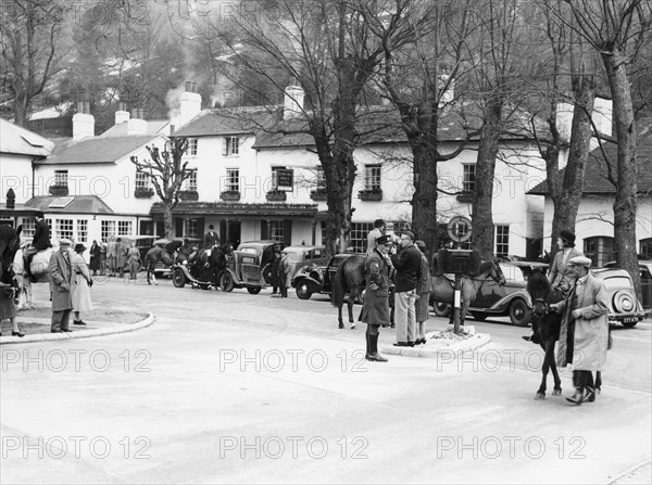 Pedestrians and riders outside the Burford Bridge Hotel, Surrey, (c1930s?). Artist: Unknown