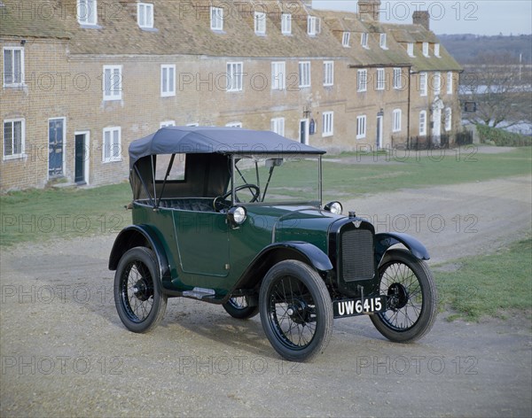 A 1929 Austin 7 in front of a row of terraced houses. Artist: Unknown