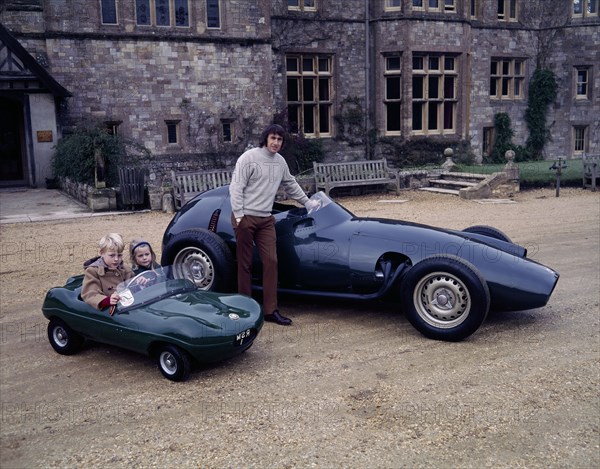 Jackie Stewart posing with a 1957 BRM. Artist: Unknown