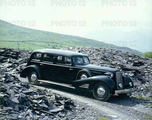 A 1937 Cadillac V16 sedan, photographed among piles of slate. Artist: Unknown