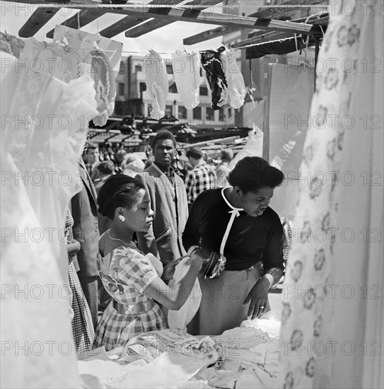 Two women looking at a stall in the Petticoat Lane Market, Whitechapel, London, c1946-c1959