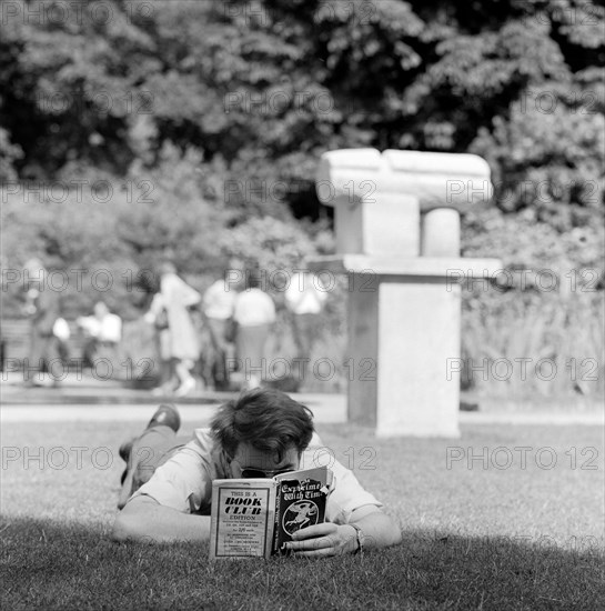 Man reading in a park, London, 1962-1964