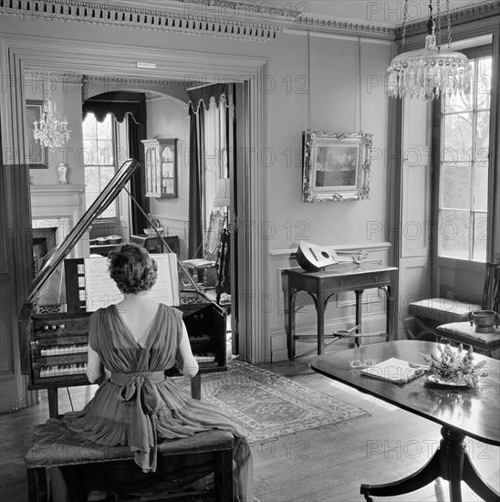 Woman in evening dress playing the harpsichord, Fenton House, London, 1960-1965