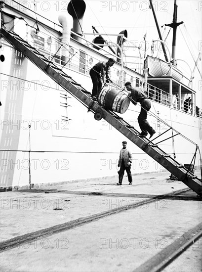 Unloading a barrel from a ship down a gangway, London, c1905. Artist: Unknown