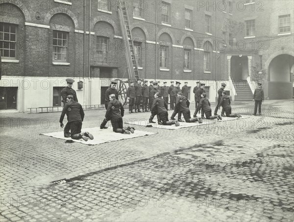 Demonstrating how to pick up an unconscious person, London Fire Brigade Headquarters, London, 1910. Artist: Unknown.