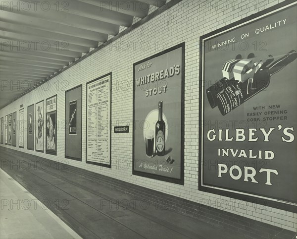 Advertisements for beer and port, Holborn Underground Tram Station, London, 1931. Artist: Unknown.