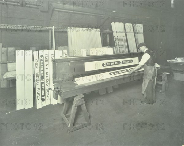 Man stencilling signs for tram cars at Charlton Central Repair Depot, London, 1932. Artist: Unknown.