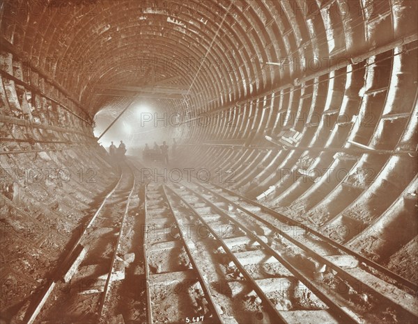 Men pushing railway trucks along the Rotherhithe Tunnel, Stepney, London, June 1907. Artist: Unknown.