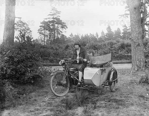 A woman riding a Douglas flat-twin motorcycle with a sidecar, 1900-1910