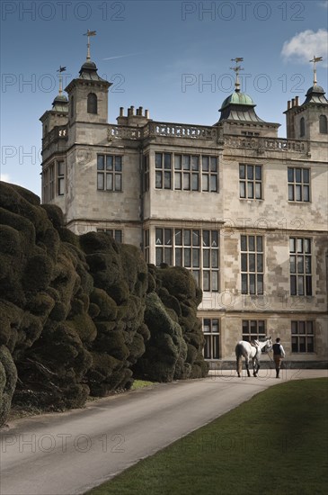 Re-enactor leading a horse towards Audley End House, Saffron Walden, Essex, 2010