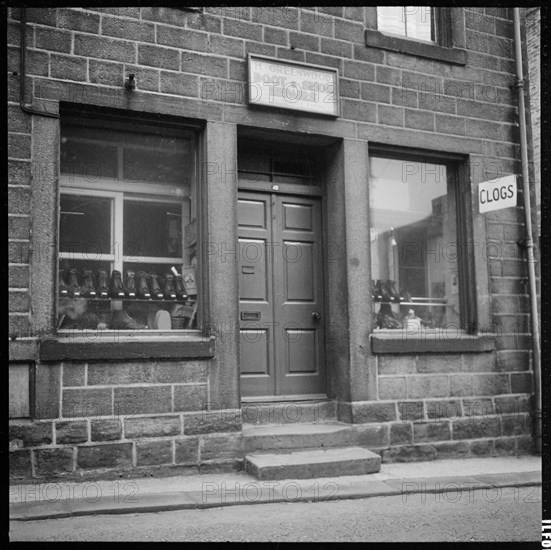 Clogs displayed in the window of H Greenwood Boot & Shoe Repairs shop, 1966-1974