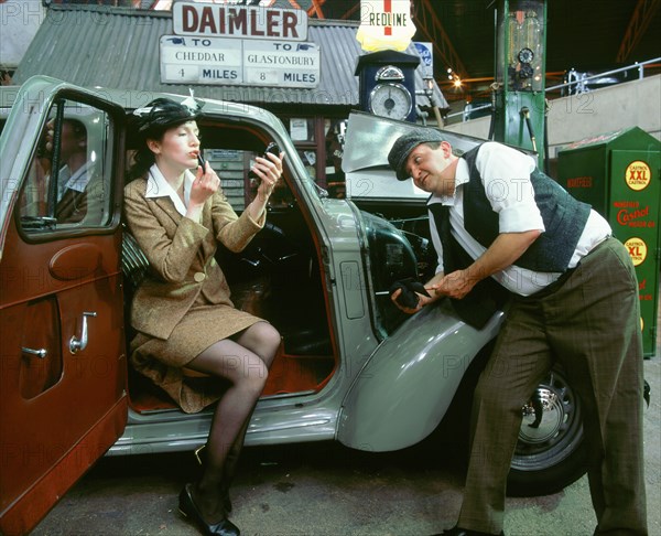 Mechanic with lady driver doing her make up, 1930's Hillman Minx. Artist: Unknown.