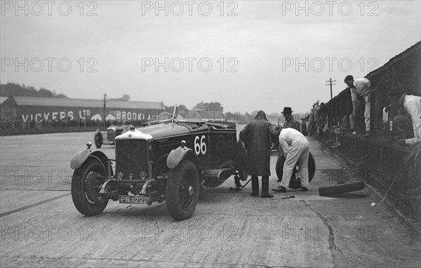 GL Baker's 5954 cc Minerva undergoing a rear wheel change at Brooklands. Artist: Bill Brunell.