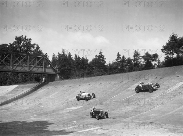 Lea-Francis 1496 cc, MG M type and Invicta 4467 cc racing on the Members Banking at Brooklands. Artist: Bill Brunell.