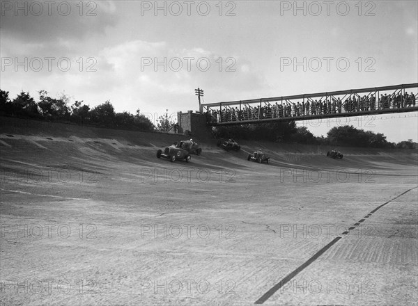 Cars racing on Byfleet Banking during the BRDC 500 Mile Race, Brooklands, 3 October 1931. Artist: Bill Brunell.