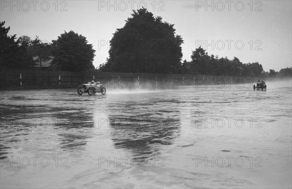 Austin 7 leading a MG in the wet at the LCC Relay GP, Brooklands, 25 July 1931. Artist: Bill Brunell.