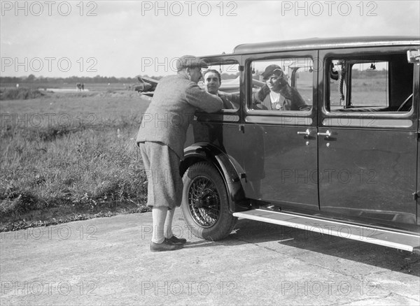 Hugh McConnell, Sammy Davis and Mrs Davis with an Austin 20/6 landaulette at Brooklands, 1931. Artist: Bill Brunell.