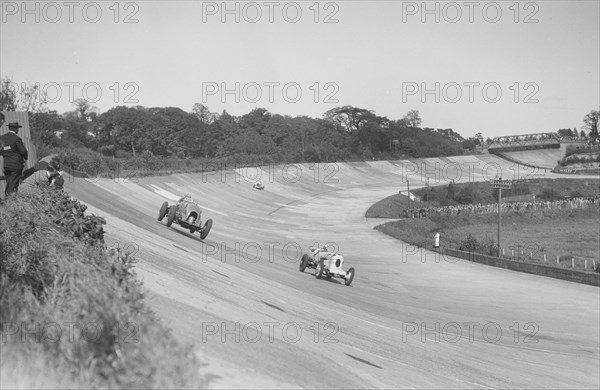 Sir Henry Birkin's Bentley racing RJ Munday's Vauxhall 30/98, BARC meeting, Brooklands, 16 May 1932. Artist: Bill Brunell.