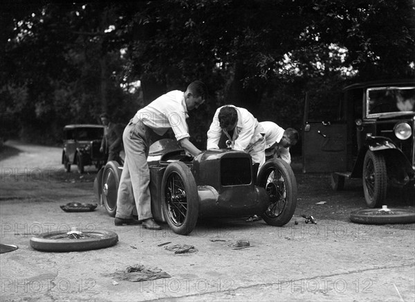 Mechanics working on Leon Cushman's Austin 7 racer for a speed record attempt, Brooklands, 1931. Artist: Bill Brunell.