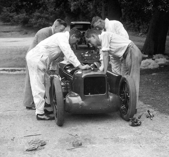 Mechanics working on Leon Cushman's Austin 7 racer for a speed record attempt, Brooklands, 1931. Artist: Bill Brunell.