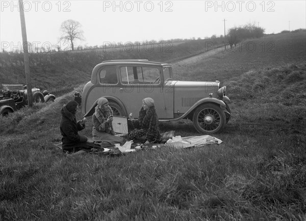 Three women having a picnic during a road test of a Triumph Scorpion, 1931. Artist: Bill Brunell.