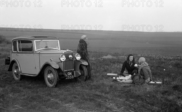 Three women having a picnic during a road test of a Triumph Scorpion, 1931. Artist: Bill Brunell.