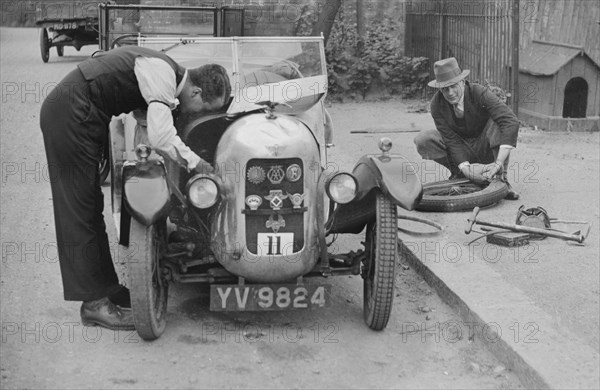 Working on the engine of E Martin's Austin Swallow at the North West London Motor Club Trial, 1929. Artist: Bill Brunell.
