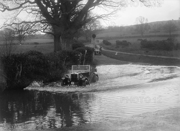 1932 Morris Minor tourer driving through a ford during a motoring trial, 1936. Artist: Bill Brunell.