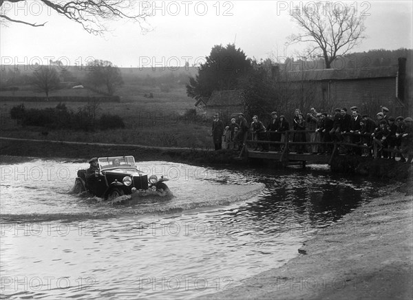 MG Magnette driving through a ford during a motoring trial, 1936. Artist: Bill Brunell.