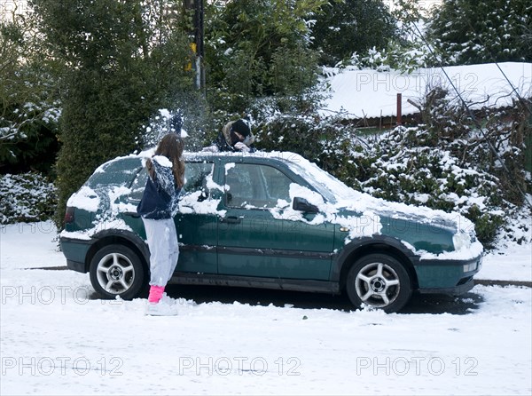 Girls palying with snowballs by VW Golf 2009 Artist: Unknown.